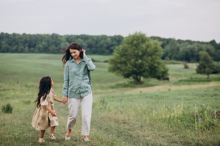 an-image-of-a-mother-and-daughter-walking-at-a-grassy-field-after-getting-a-divorce